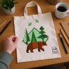 Sac en toile imprimé illustration vectorielle d’un ours brun au milieu d’arbres verts et de montagnes, sur une table avec écran